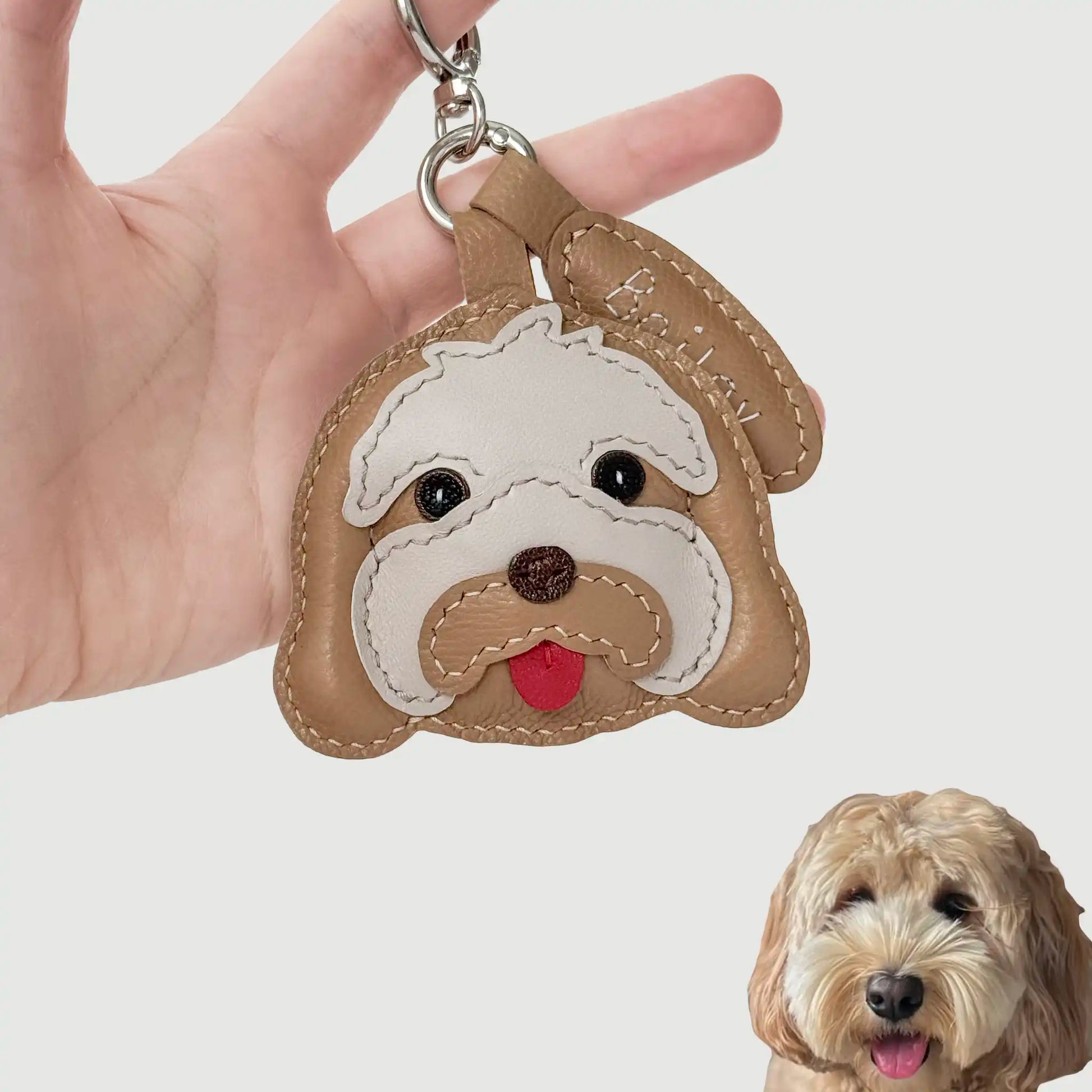 Custom-made handcrafted leather charm of Bailey, an Australian Labradoodle, with layered textures and a playful tongue.