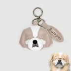 Dog-shaped keychain with 'Bumper' on a light gray background, next to a real dog.
