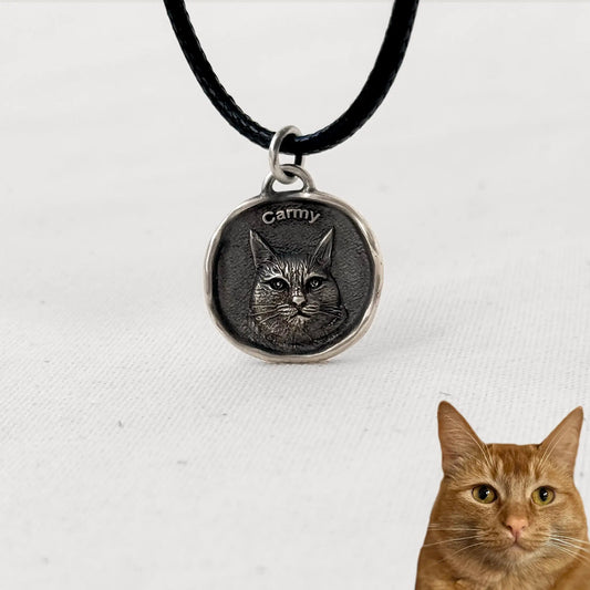 Custom silver cat pendant with engraved portrait of Carmy, ginger tabby cat, on a black cord necklace.
