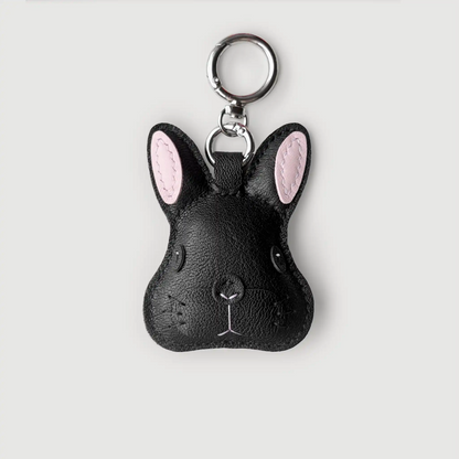 Black rabbit-shaped keychain with pink ears on a light gray background
